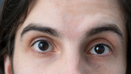 Close-up of surprised or scared man looking at camera