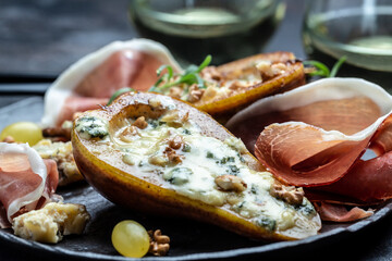 Appetizer with pear baked with blue cheese, nuts and honey, prosciutto. Summer snacks. Pear appetizer with jamon, Long banner format. top view.
