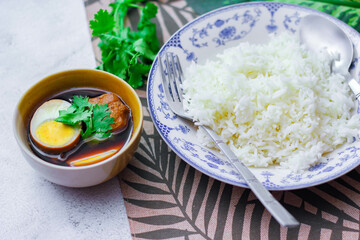 Steamed rice in an ancient plate and Stewed Eggs, Thai food and street food that are common in Thailand.