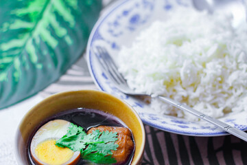 Steamed rice in an ancient plate and Stewed Eggs, Thai food and street food that are common in Thailand.