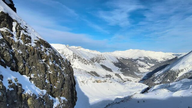 snowy mountains and rocky cliffs in a winter wonderland in the alpes drone 4k dolly reveal shot