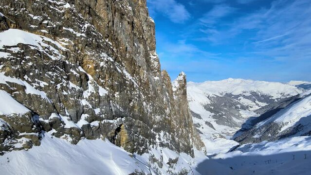 snowy mountains and rocky cliffs in a winter wonderland in the alpes drone 4k truck shot.