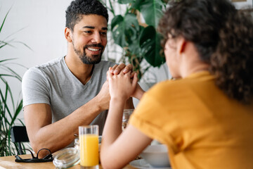 Happy african american couple in love having breakfast together in the kitchen