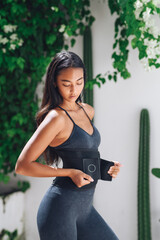 Athletic girl with sweat belt after training.