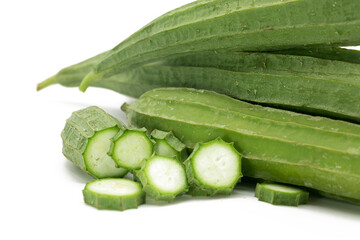 Angled luffa or Ridge gourd slice close up over on white background, selective focus