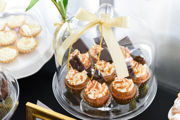 Tasty cupcakes with chocolate and caramel sause on a sweet table at a wedding party