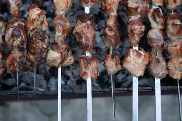 Georgian national dish meat on a spit, grilled on a large metal grill with hot charcoal, the meat is golden brown.