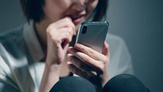 精神障害を患っている若い女性がスマートフォンを使っている