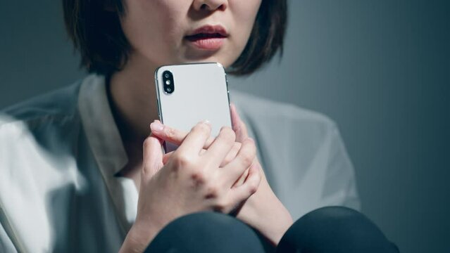 精神障害を患っている若い女性がスマートフォンを使っている