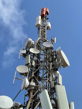 Telecommunication and mobile network infrastructure with two cell site towers side by side, housing antennas and Remote Radio Head, RRH, for greater coverage