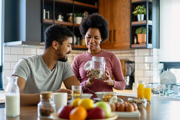 Happy african american couple having breakfast together in the kitchen