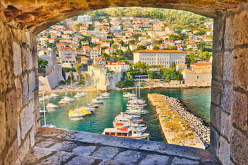 window view from Dubrovnik city walls of harbour of Dubrovnik city in Croatia. Dubrovnik historic city of Croatia in Dalmatia. UNESCO Venetian architecture. Fort Lovrijenac fortress on background. - obrazy, fototapety, plakaty