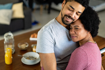 Happy couple having breakfast together in the kitchen - Powered by Adobe