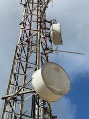 Telecommunication and mobile network infrastructure with two cell site towers side by side, housing antennas and Remote Radio Head, RRH, for greater coverage