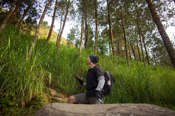 One backpacker man travel alone, with backpack in the mountains
