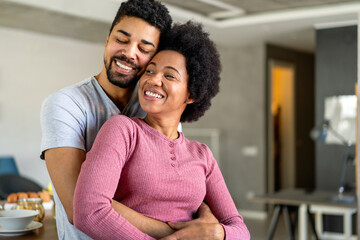 Obraz premium Portrait of happy smiling black couple in love having fun and hugging together