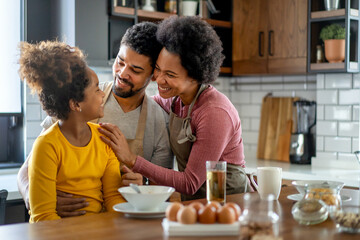Happy african american family preparing healthy food together in kitchen