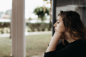 Calm pretty teenager girl on the balcony looking away