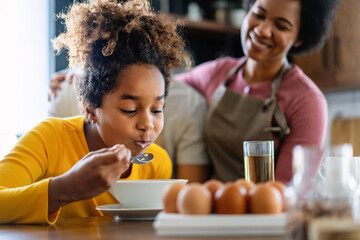 Happy african american family preparing healthy food together in kitchen
