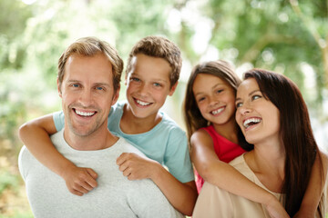 Making happy memories together. Portrait of a happy family of four spending time together outdoors.