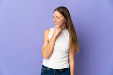 Young Lithuanian woman isolated on purple background looking to the side and smiling
