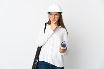 Young Lithuanian architect woman with helmet and holding blueprints isolated on white background having doubts