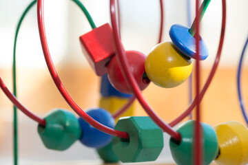 colored blocks on a spiral - circle Bead Maze - educational toy for children, background in the theme of child development