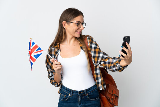 Young Lithuanian woman holding an United Kingdom flag isolated on white background making a selfie