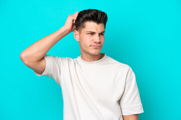 Fototapeta premium Young handsome caucasian man isolated on blue bakcground having doubts while scratching head
