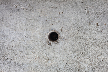 The circular hole is in the concrete wall.