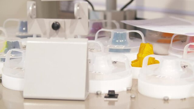 Maintenance of bellows pump with yellow pigment canister. Process of pouring yellow paint