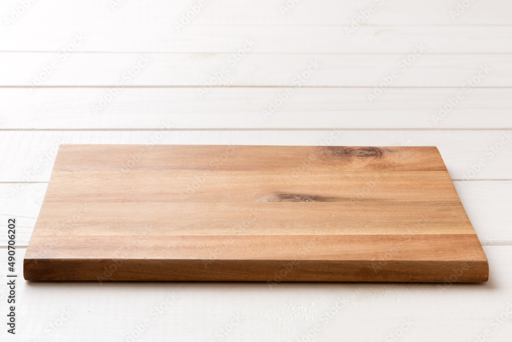 Wall mural perspective view of wooden cutting board on wooden background. empty space for your design