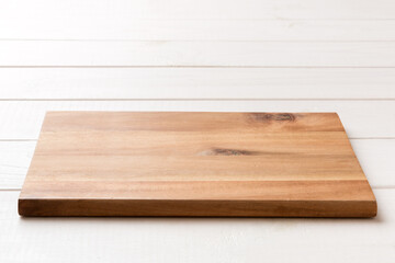 Perspective view of wooden cutting board on wooden background. Empty space for your design