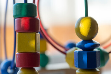 a pyramid of colored cubes and spheres -circle Bead Maze -  is a light background on the theme of baby development