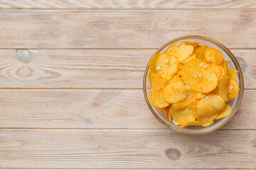 Potato chips on bowl isolated on colored background. Delicious crispy potato chips in bowl. Space for text. Top view