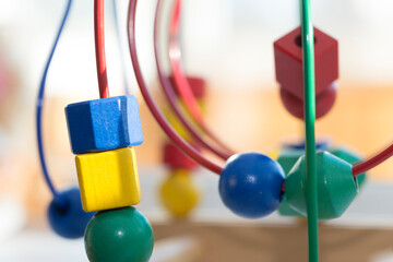 colored blocks on a spiral - circle Bead Maze - educational toy for children, background in the theme of child development