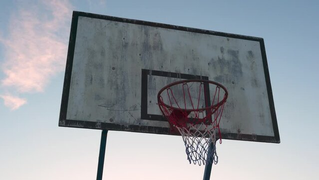 Old basketball hoop against an evening sky