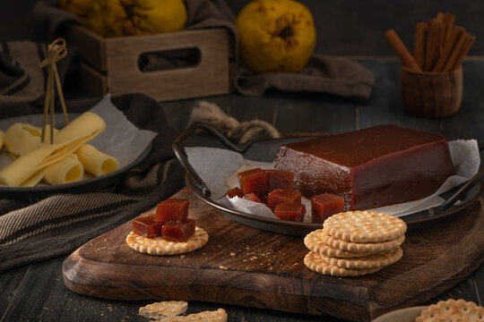 Quince cheese or marmelada is a sweet, thick jelly made of the pulp of the quince fruit. Marmalade in crackers on a kitchen counter. Dulce de membrillo in Spain