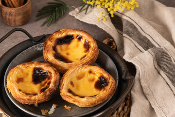 Traditional Portuguese pastry Pastel de Nata or Pastel de Belém served with cinnamon powder in a...
