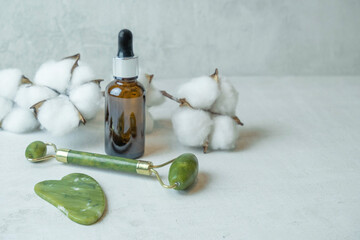 jade roller for facial massage gouache scraper brown bubble with serum , the concept of facial...