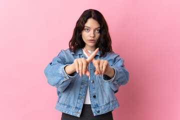 Teenager Ukrainian girl isolated on pink background making stop gesture with her hand to stop an act