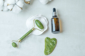 jade roller for facial massage gouache scraper brown bubble with serum , the concept of facial massage and home facial skin care