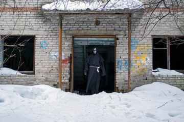 Grim Reaper Standing over Old Derelict Brick Building and Looking at Camera
