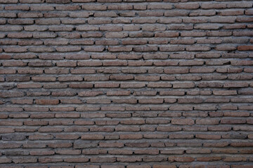 facade of an old clay brick building where only masonry bricks can be seen that create an interesting pattern and shape