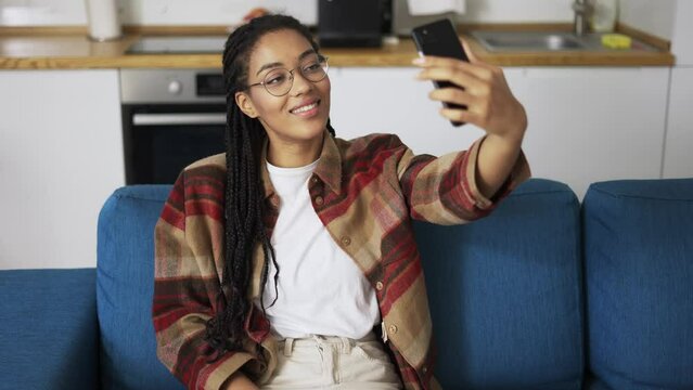 Young beautiful smiling girl with dreadlocks taking selfie picture with smart phone camera