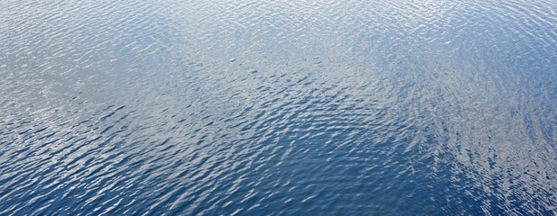 Ripple on the water surface. Ocean or sea water background under the sun rays