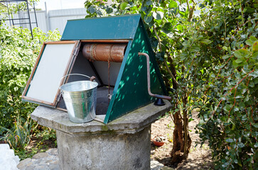 Old draw-well in European village. Retro stone water well in rural area