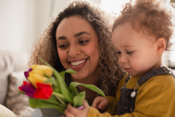 Toddler giving Mother flowers for Mothers Day