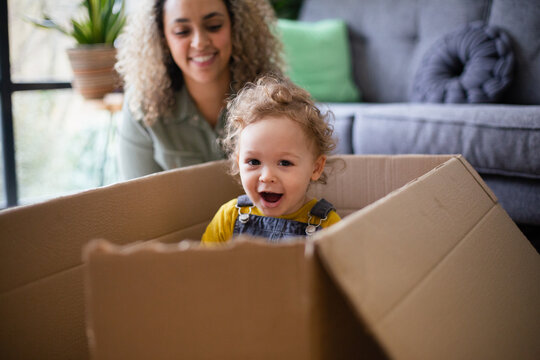 Mother and Toddler playing with a cardboard box