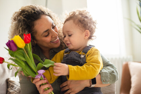 Toddler giving Mother flowers for Mothers Day
